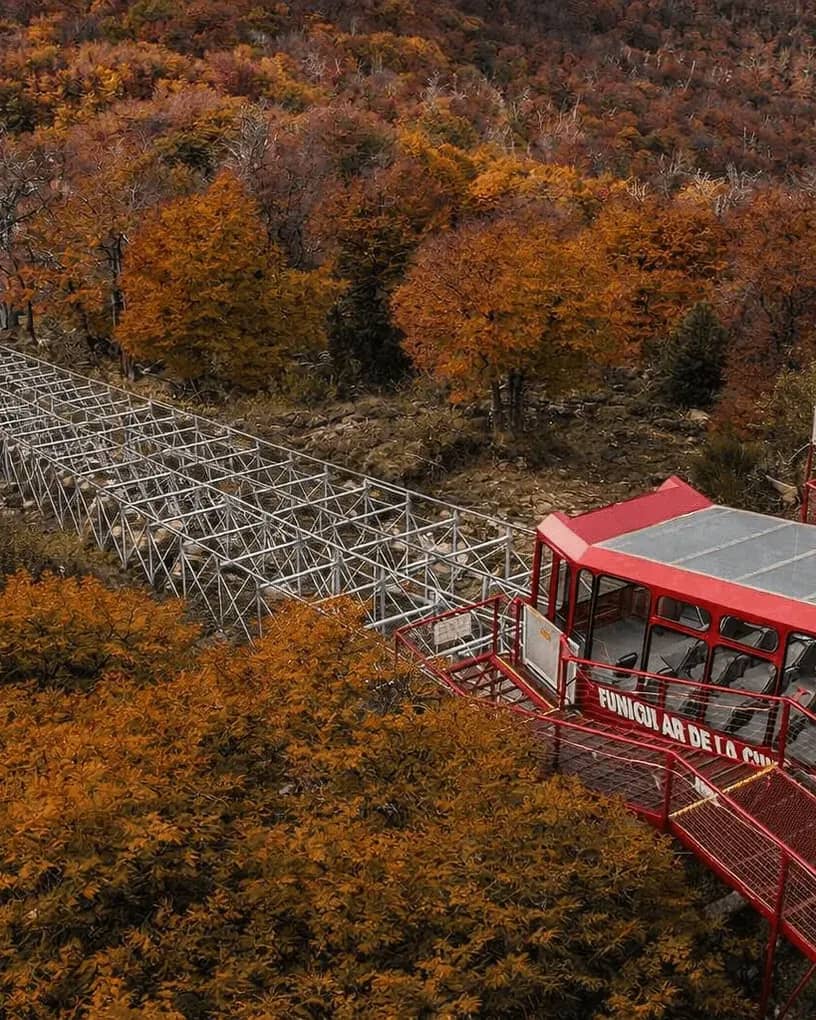 Vista superior del funicular en la estacion superior con un fondo otoñal