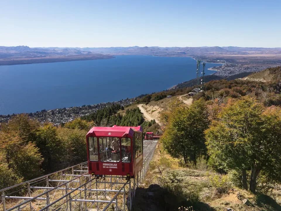 Vista de frente del funicular de la cumbre ascendiendo con el lago Nahuel Huapi de fondo