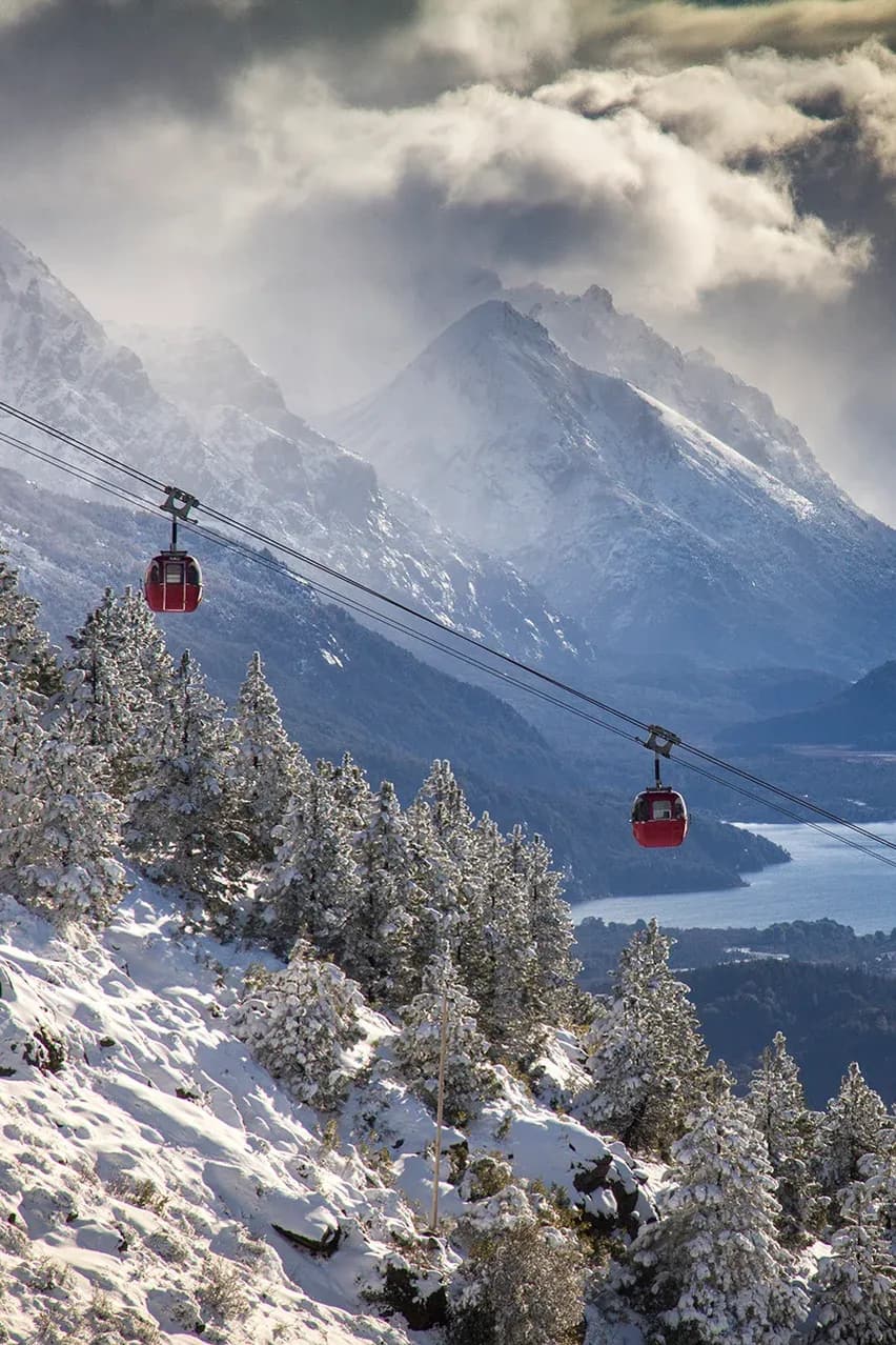 Dos telefericos viajando con el lago Nahuel Huapi de fondo